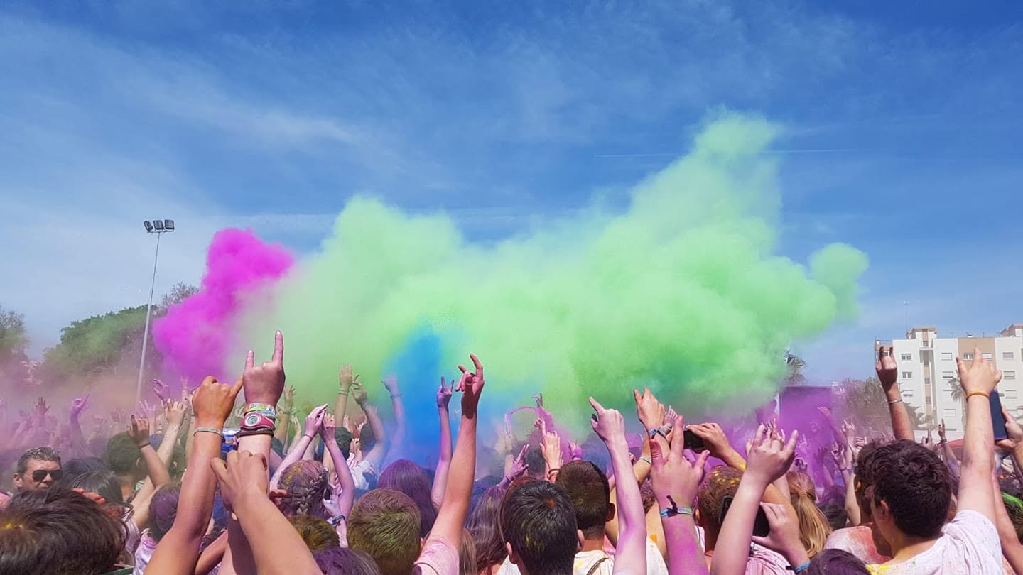 Jóvenes disfrutando de una actividad festiva con polvos de colores